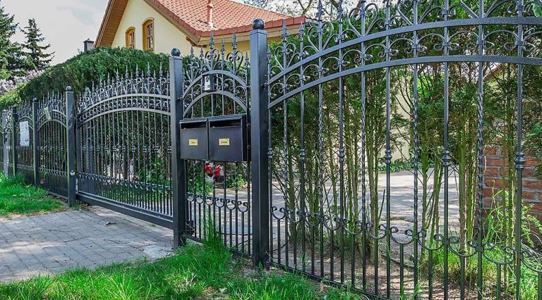 Metallzaun auf dem Betonsockel, Punktfundament oder in einer Mauer